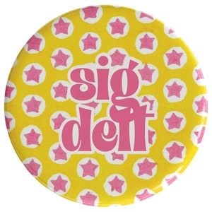 May include: A yellow button with pink stars and the text "sig deft" in pink.