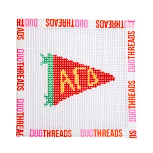 May include: A square needlepoint canvas featuring a red triangular pennant with the yellow letters AFD in the center and a green stitched border. The white canvas edges are printed with the repeating pink and orange text DUOTHREADS.