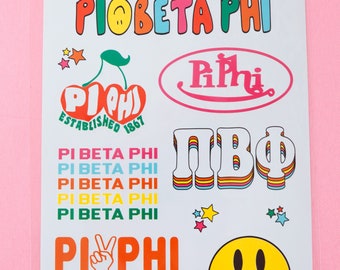 May include: A sheet of colorful stickers featuring the Greek letters Pi Beta Phi. The stickers include a cherry with the letters "Pi Phi" inside, a smiley face, a disco ball, and the letters "Pi Beta Phi" in various styles.