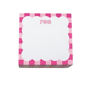 May include: A square notepad with a pink and white checkered border. The notepad has a white, scalloped-edge center with the Greek letters ΓΦB in pink. The notepad is on a white background.