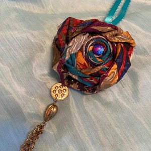 Rosettes (made from upcycled men&#39;s ties) and repurposed jewelry and beads.