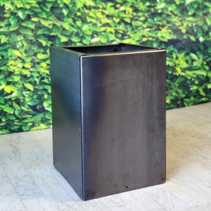 May include: A square metal planter with a dark gray finish. The planter is made of sturdy metal and has a simple, modern design.