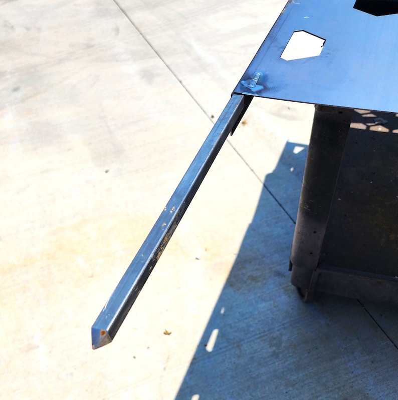 May include: A close-up of a metal rod with a pointed end. The rod is attached to a metal frame.