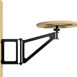 May include: A black metal wall-mounted table with a round wooden top. The table is attached to the wall with a bracket and has a swiveling arm.