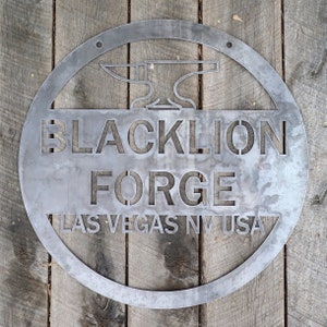 May include: A round metal sign with the text "Blacklion Forge Las Vegas NV USA" and a stylised image of an anvil.