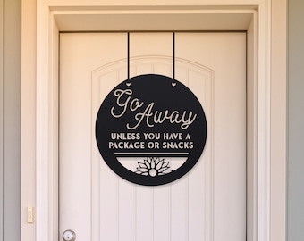 May include: Black and white round door sign with the text "Go Away unless you have a package or snacks".