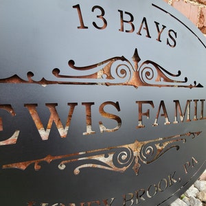 May include: Black metal sign with a decorative scroll design and the text "13 Bays Lewis Family Honey Brook, PA".