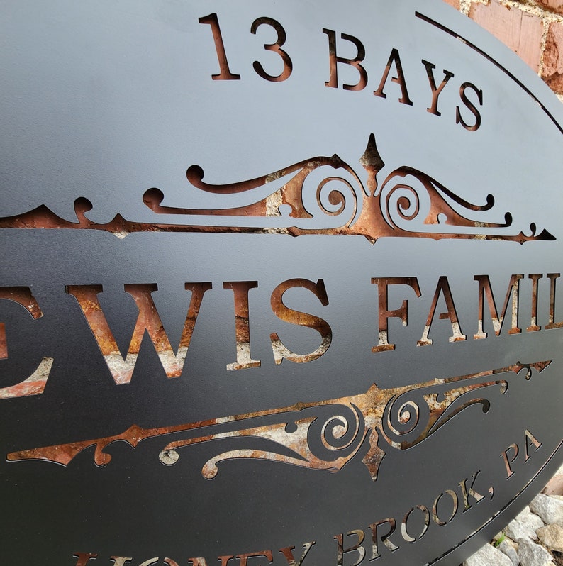 May include: Black metal sign with a decorative scroll design and the text "13 Bays Lewis Family Honey Brook, PA".