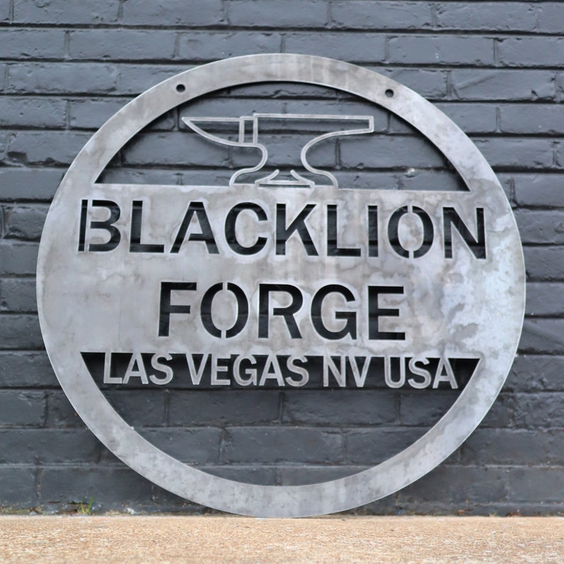May include: A circular metal sign with the text "Blacklion Forge Las Vegas NV USA" and a silhouette of an anvil and hammer.