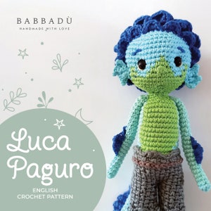 May include: A handmade crochet doll in the likeness of Luca Paguro, featuring a blue and green color scheme. The doll has a detailed design, including a textured head, body, and gray pants. The image also includes the text "Luca Paguro" and "English Crochet Pattern".