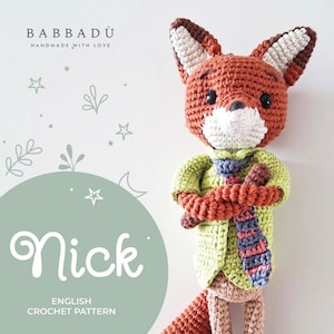 Può includere: Una bambola di volpe all'uncinetto fatta a mano di nome Nick, che indossa una giacca verde e una cravatta a righe. La volpe è principalmente arancione con dettagli bianchi e marroni. L'immagine include il testo "BABBADÙ HANDMADE WITH LOVE" e "Nick ENGLISH CROCHET PATTERN".