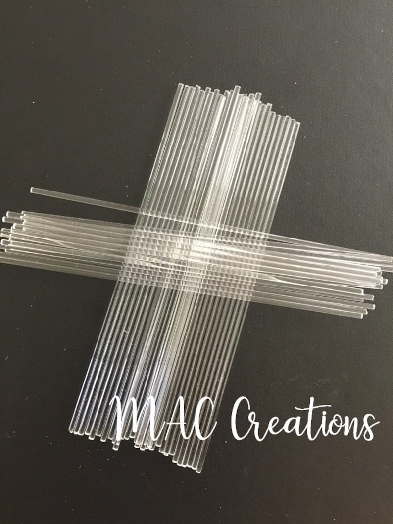 Op de afbeelding: Een bundel doorzichtige plastic stokjes, gerangschikt in een kruisvorm, op een zwarte achtergrond. De tekst "MAC Creations" is zichtbaar in de rechterbenedenhoek van de afbeelding.