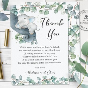 May include: A thank you card with a watercolor illustration of a baby elephant sleeping on a branch with eucalyptus leaves. The text reads "Thank You" and includes a message expressing gratitude for gifts and wishes for a new baby. The card is designed for a baby shower or new baby celebration.