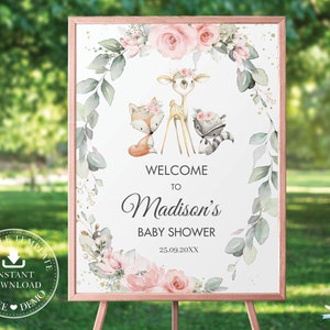 Może przedstawiać: Oprawiony szyld na baby shower z ramą w kolorze różowego złota. Znak zawiera akwarelowe ilustracje lisa, jelenia i szopa pracza, otoczone elementami kwiatowymi i liśćmi. Tekst brzmi "Witamy na baby shower Madison" i data.