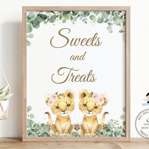 May include: Printable sign with the text "Sweets and Treats" in gold script. The sign features two watercolor illustrations of lion cubs with pink flower crowns, surrounded by green eucalyptus leaves.