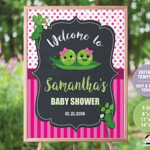 May include: A pink and green baby shower welcome sign with a chalkboard background. The sign features two cartoon peas with faces and the text "Welcome to Samantha's Baby Shower 10.21.2018".