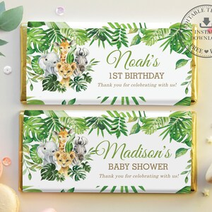 May include: Two printable chocolate bar wrappers with a jungle theme. The top wrapper says "Noah's 1st Birthday" and the bottom wrapper says "Madison's Baby Shower". Both wrappers feature a green leafy border with a giraffe, zebra, lion, and elephant.