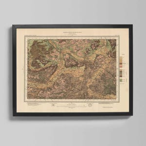 May include: Framed vintage map in a black frame. The map shows a detailed illustration with various colours, including shades of brown, green, and beige. The map is a geological survey of a region, with text at the top and bottom.