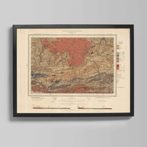 Może przedstawiać: Oprawiony, zabytkowy wydruk mapy w czarnej ramie. Mapa przedstawia szczegółowe badanie geologiczne z odcieniami czerwieni, brązu i błękitu. Mapa jest zamontowana na kremowym tle. Widoczny jest tekst na górze mapy.