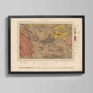 May include: Framed vintage map print with a detailed geological illustration. The map features a complex arrangement of colors, including shades of red, yellow, brown, and gray, within a black frame. The print is mounted on a cream-colored background.