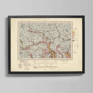 Puede incluir: Mapa vintage enmarcado en un marco negro. El mapa presenta información geográfica detallada con colores rosa, amarillo y marrón sobre un fondo crema. El mapa está montado en una pared gris claro.