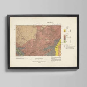 Puede incluir: Impresión de mapa vintage enmarcada en un marco negro. El mapa presenta un estudio geológico detallado con áreas codificadas por colores, incluyendo tonos de rosa, amarillo y verde. El mapa está montado sobre un fondo crema.