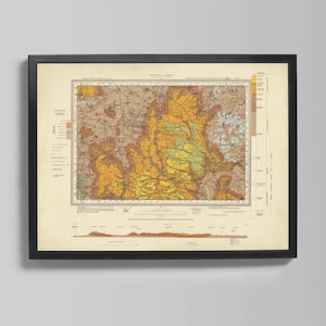 Op de afbeelding: Ingelijste vintage kaartprint met een gedetailleerde geologische illustratie. De kaart heeft een kleurenpalet van geel, bruin en groen, met een zwarte lijst. De print is gemonteerd op een crèmekleurige achtergrond, geschikt voor decoratie.