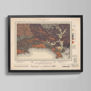 Puede incluir: Mapa vintage enmarcado con borde negro. El mapa presenta una ilustración detallada de una región costera, con varios colores que indican diferentes características geográficas. El mapa incluye texto y está montado sobre un fondo neutro.
