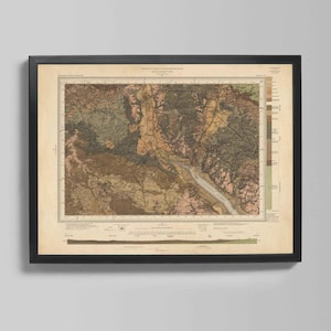 May include: Framed vintage map print in a black frame. The map shows a detailed, multi-coloured geological survey of an area, with shades of brown, green, and beige. The map is mounted on a cream-coloured background.