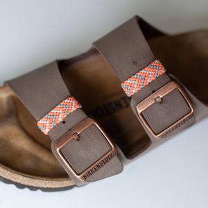 May include: A set of three ceramic mugs with a speckled, matte finish. The mugs are in shades of cream, light gray, and dark gray. Each mug has a simple, minimalist design, perfect for coffee or tea.