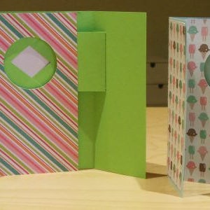 Può includere: Due progetti di carte verdi e bianche. La prima carta ha un motivo a righe con un cerchio ritagliato. La seconda carta ha un motivo di coni gelato con palline di diversi colori.