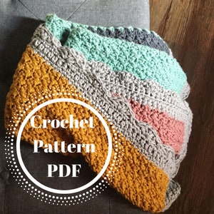May include: A crochet pattern PDF for a multi-colored blanket with stripes of mustard yellow, gray, pink, and teal.