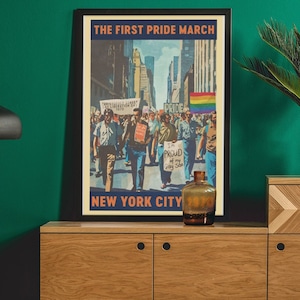 Może przedstawiać: Wizerunek vintage z tekstem "The First Pride March New York City" przedstawiający tłum ludzi maszerujących ulicą miasta. Plakat jest oprawiony i wisi na zielonej ścianie nad drewnianym regałem z rośliną na górze.