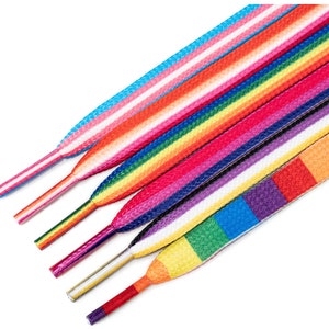 May include: A set of six colourful shoelaces with a rainbow stripe pattern. The shoelaces are made of a woven fabric and have a white background.