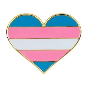 May include: A gold heart-shaped pin with a transgender pride flag design. The flag has five horizontal stripes: light blue, pink, white, pink, and light blue.