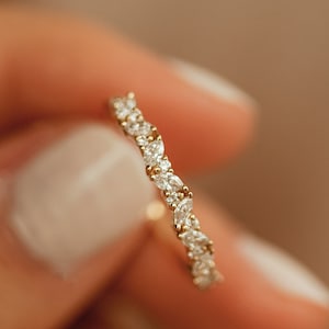Puede incluir: Un delicado anillo de banda de oro con una fila de pequeños diamantes transparentes de forma marquesa engastados en pavé.
