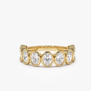 May include: A gold band ring with seven bezel-set oval diamonds. The ring is engraved with the word "FERROS".