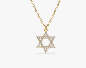 May include: A gold-colored necklace featuring a Star of David pendant. The pendant is encrusted with small, sparkling gemstones, creating a brilliant effect. The necklace has a delicate chain, and the pendant is centered. The background is plain white.