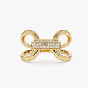 May include: A gold ring with a double-loop design and a center oval section set with small diamonds.