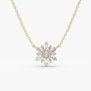 May include: A gold chain necklace featuring a dainty diamond snowflake pendant. The snowflake is crafted from baguette-cut diamonds and has a round brilliant-cut diamond at its centre.