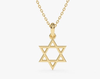 May include: A gold-colored Star of David pendant necklace. The pendant is a six-pointed star, suspended from a delicate chain. The necklace is displayed against a plain white background, highlighting the jewelry's design.