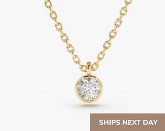 Può includere: Una delicata collana a catena d'oro con un ciondolo rotondo in diamante a bezel.