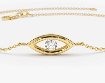 May include: A gold chain bracelet with a single diamond set in a gold eye-shaped pendant.