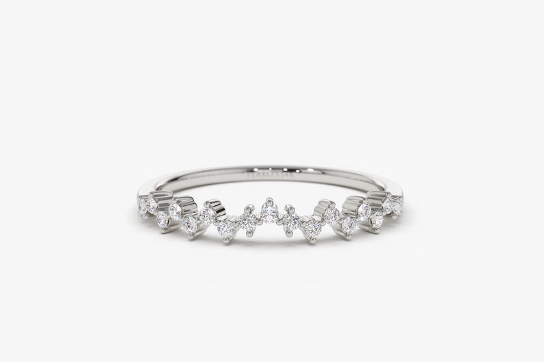 Puede incluir: Un delicado anillo de banda de plata con una l&iacute;nea ondulada de peque&ntilde;os diamantes.