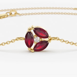 May include: A gold chain bracelet with a cluster of red ruby stones and a single diamond in the center.