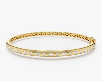 Puede incluir: Un brazalete de oro con una fila de diamantes de forma marquesa y redondos.