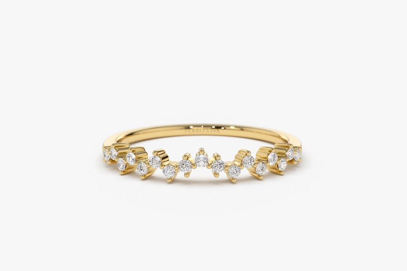 Puede incluir: Un delicado anillo de banda de oro con una fila escalonada de peque&ntilde;os diamantes brillantes.