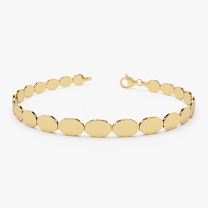 May include: A gold bracelet with a chain made of oval-shaped links.