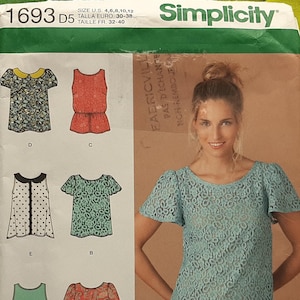 May include: Simplicity sewing pattern featuring various blouse designs. The pattern includes images of blouses with different styles, including short sleeves, long sleeves, and various necklines. The pattern cover has the text "Simplicity" and the pattern number "1693 D5".