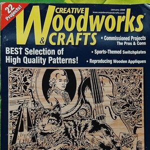 May include: The cover of "Creative Woodworks & Crafts" magazine features a wooden art piece of a cat, violin, and a portrait. The magazine's title is in yellow and white, with the issue date of January 2008. The cover also includes text about projects and patterns.